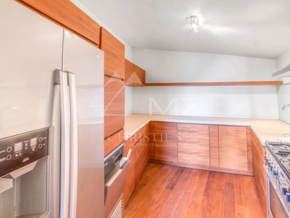 Cuisine moderne avec des meubles en bois et des appareils électroménagers en inox.
