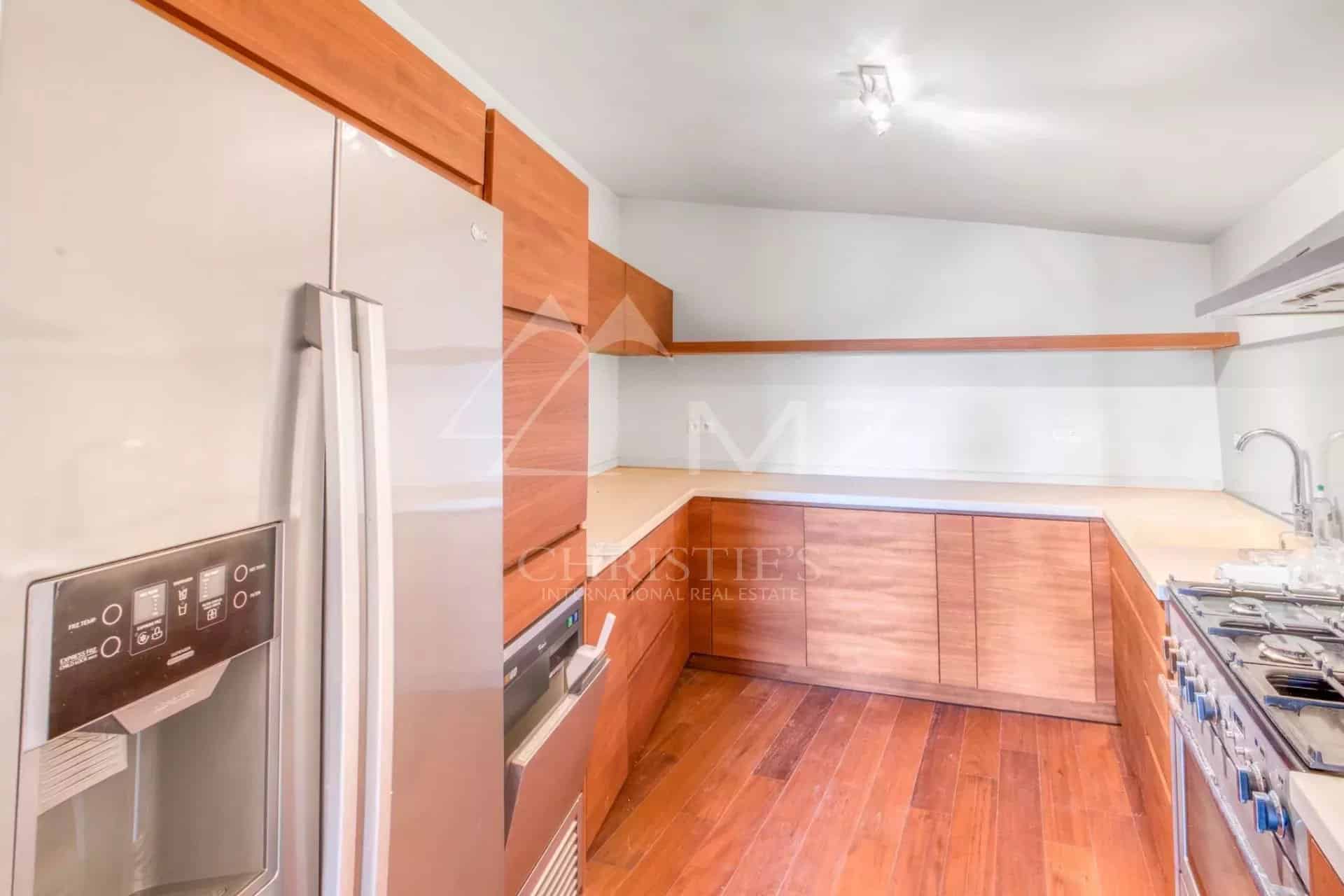 Cuisine moderne avec des meubles en bois et des appareils électroménagers en inox.