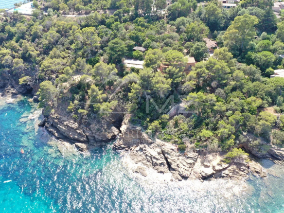 Vue aérienne d'une propriété en bord de mer avec des arbres et des rochers au Lavandou.