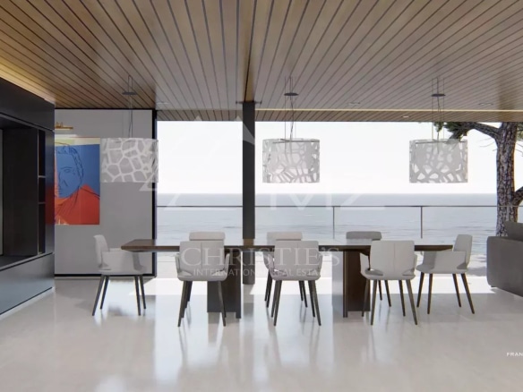 Intérieur moderne d'une propriété avec vue sur la mer, salle à manger et grandes fenêtres.