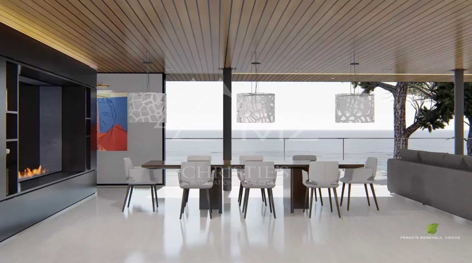 Intérieur moderne d'une propriété avec vue sur la mer, salle à manger et grandes fenêtres.