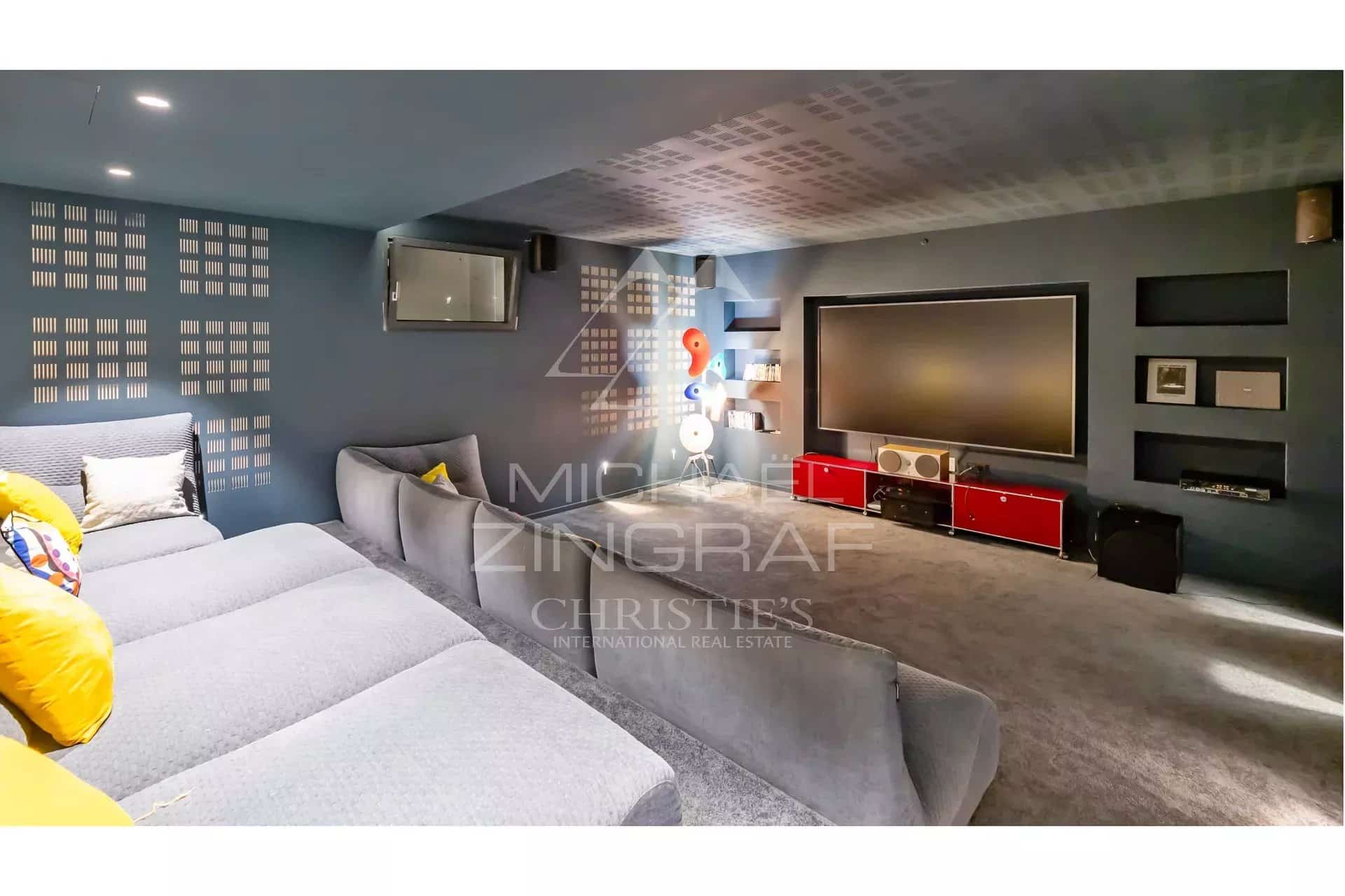 Interior of a contemporary villa with a living room and a television screen.