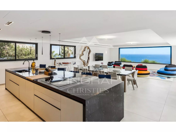 Modern interior of a villa with open kitchen and sea view.