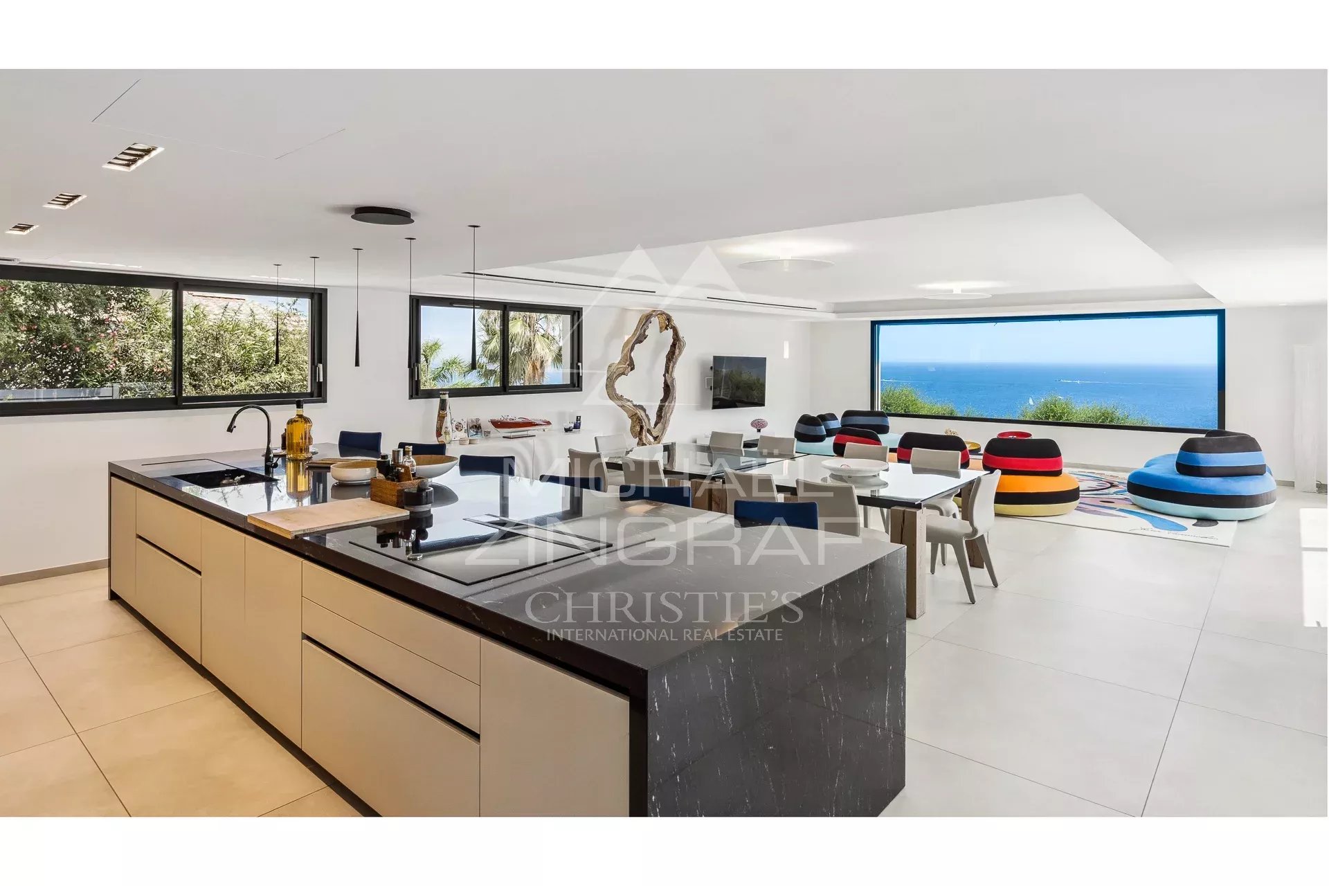 Modern interior of a villa with open kitchen and sea view.