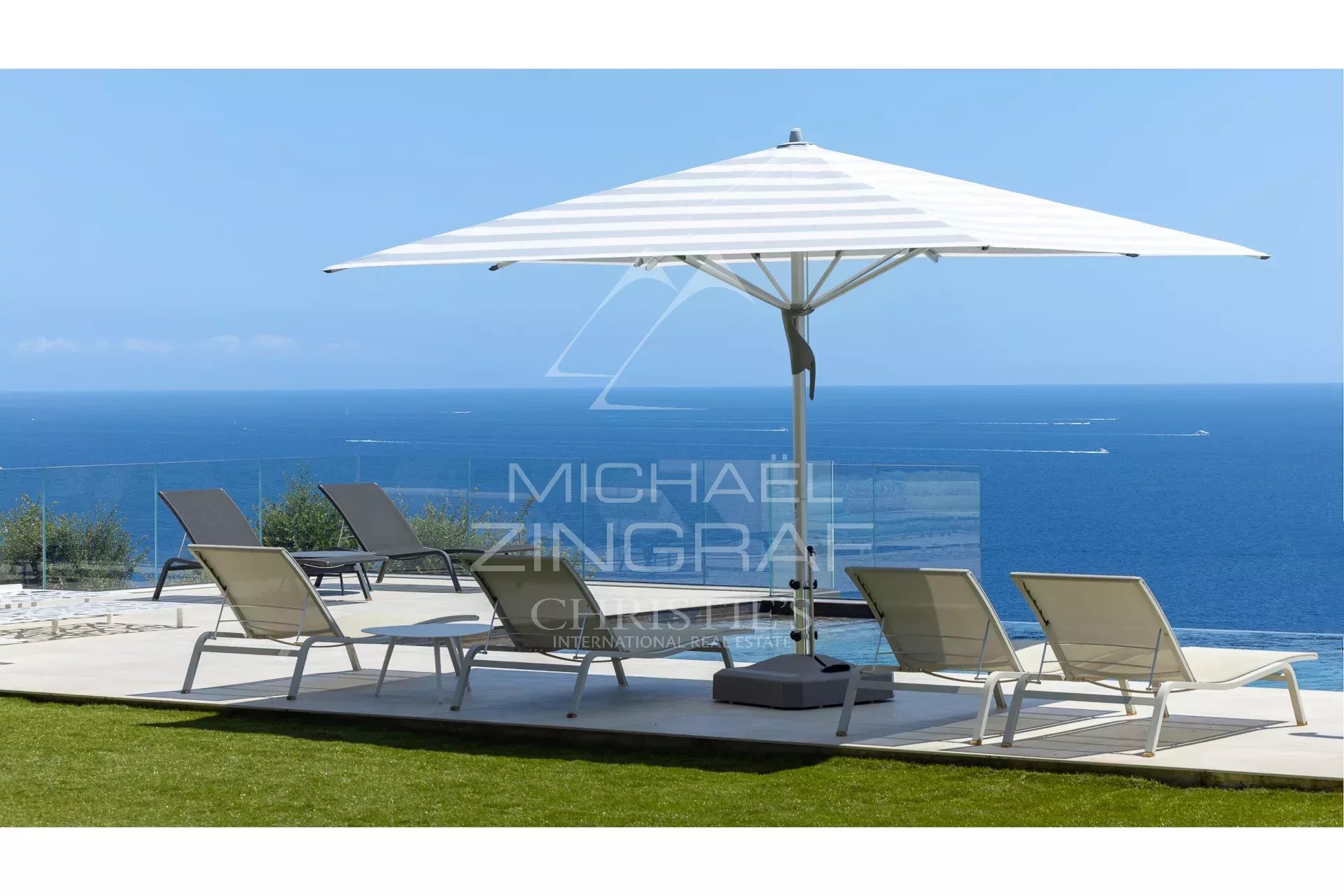 Terrace with sun loungers and parasol, sea view from Les Issambres.
