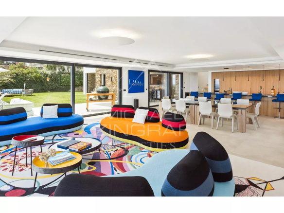 Modern interior of a villa with colorful living room and open kitchen.