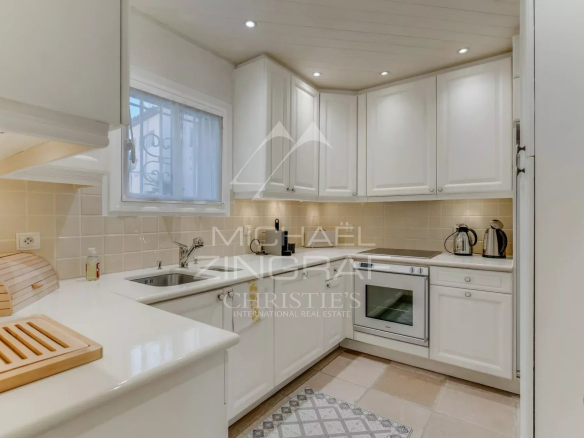 Cuisine moderne et lumineuse d'une villa à Port Grimaud, avec des meubles clairs et des appareils en inox.