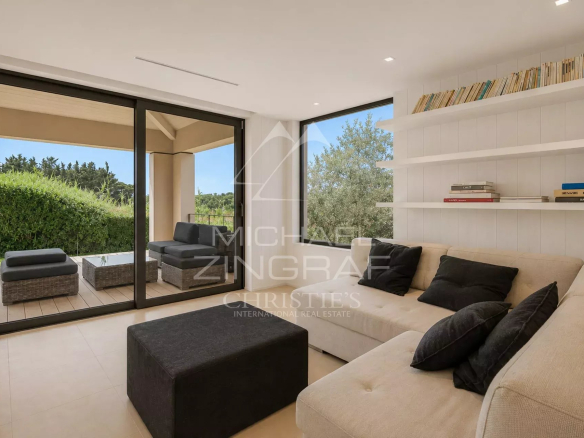 Intérieur lumineux d'une maison moderne avec un salon confortable et des grandes fenêtres.