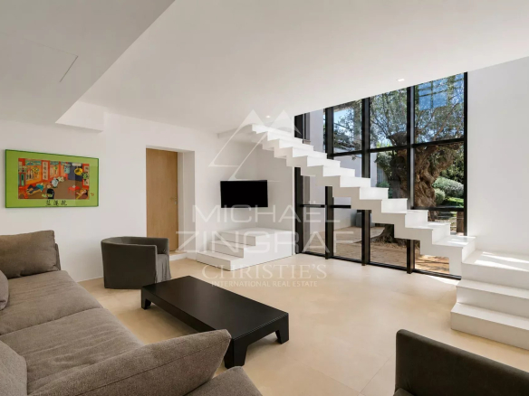 Intérieur lumineux d'une maison moderne avec un salon et un escalier design.