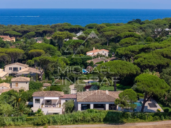 Vue aérienne d'une maison spacieuse entourée de jardins, près de la plage des Salins à Saint-Tropez.
