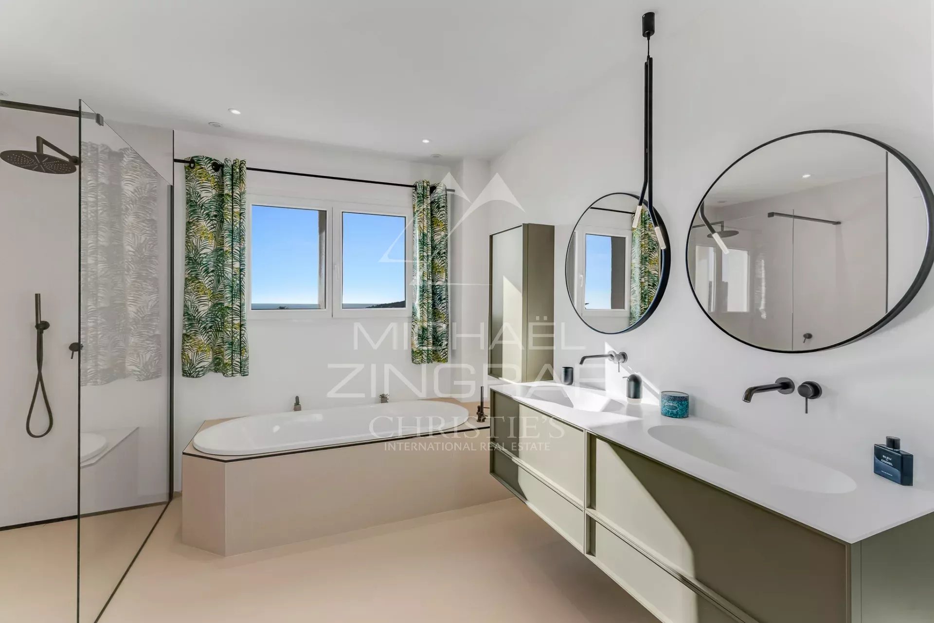 Salle de bain avec vue Salle de bain moderne avec baignoire et douche, fenêtres offrant une vue sur la mer.