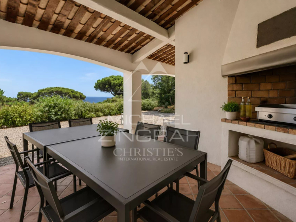 Terrasse d'une villa à Sainte-Maxime avec table et barbecue, vue sur la nature environnante.