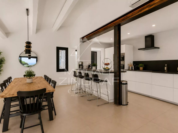 Intérieur d'une villa moderne avec une grande table à manger et une cuisine ouverte à Sainte-Maxime.