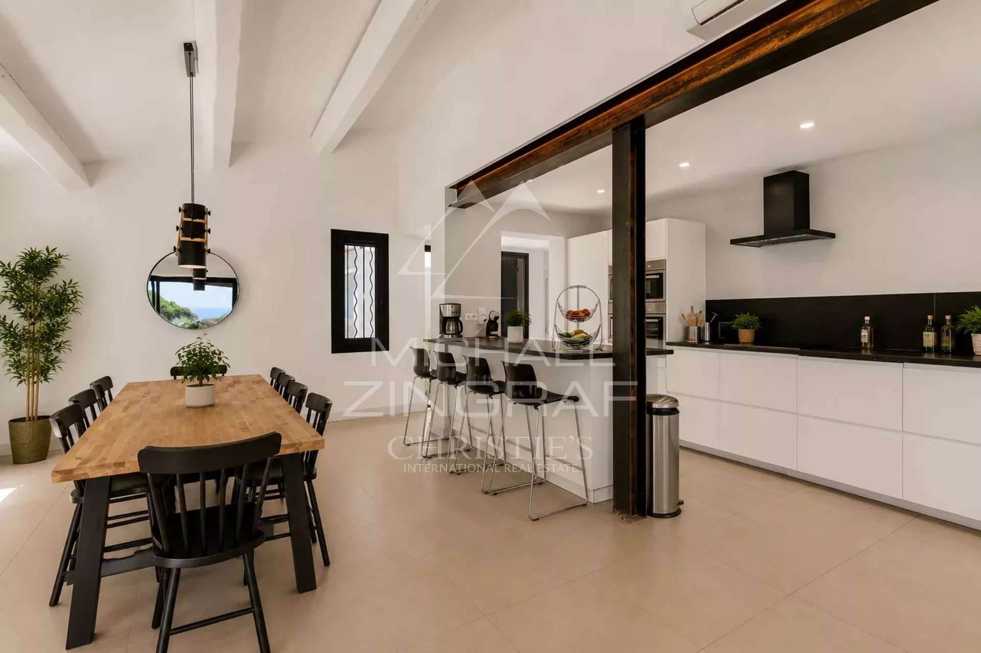 Intérieur d'une villa moderne avec une grande table à manger et une cuisine ouverte à Sainte-Maxime.
