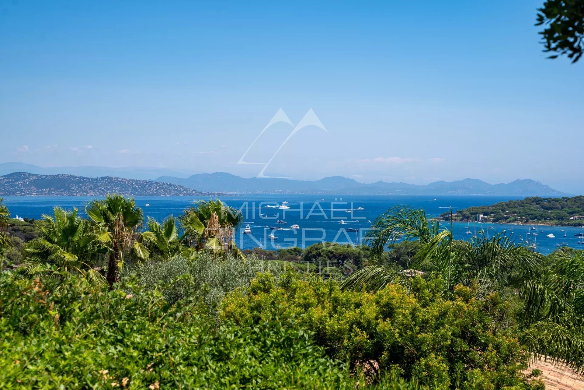 Vue sur la mer à Saint-Tropez Vue panoramique sur la mer depuis une propriété à Saint-Tropez, entourée de verdure.