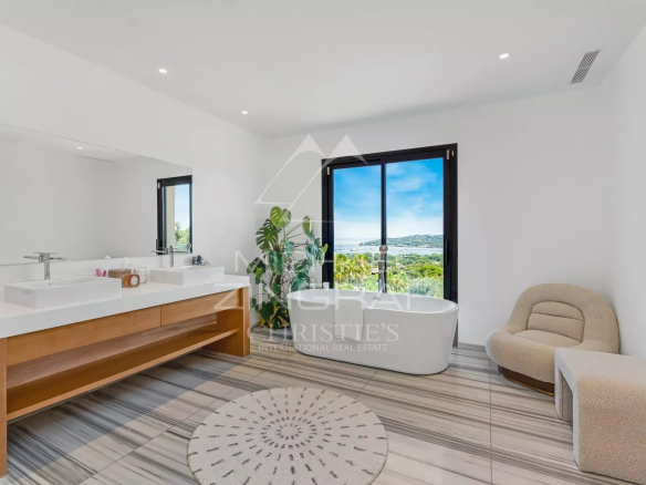 Salle de bain moderne avec baignoire et vue sur la mer à Saint-Tropez.