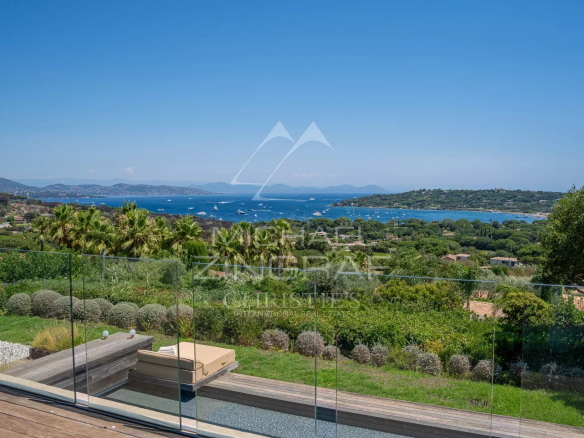 Vue panoramique sur la mer depuis une propriété à Saint-Tropez, avec jardin et terrasse en bois.