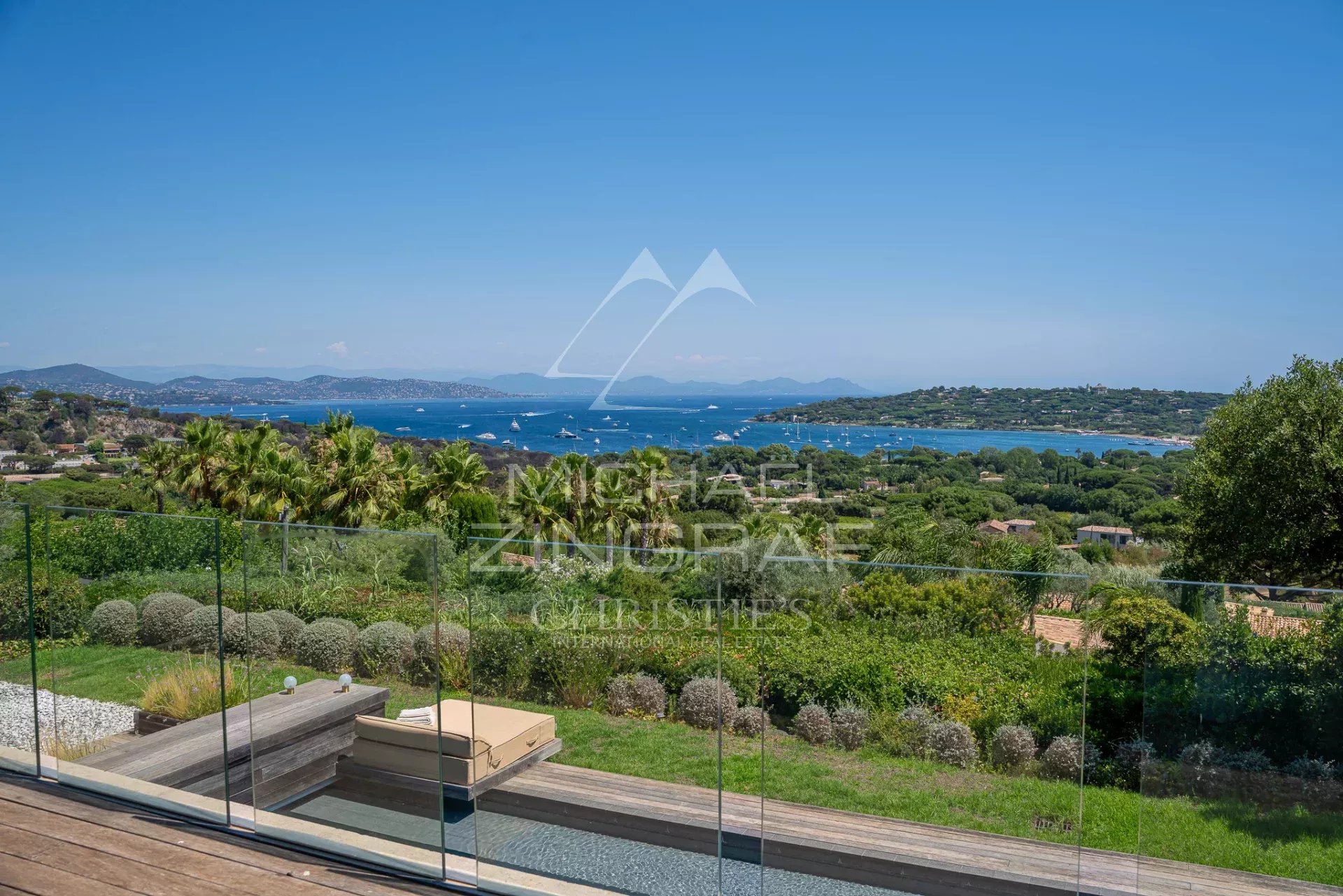 Propriété à Saint-Tropez avec vue sur la mer Vue panoramique sur la mer depuis une propriété à Saint-Tropez, avec jardin et terrasse en bois.