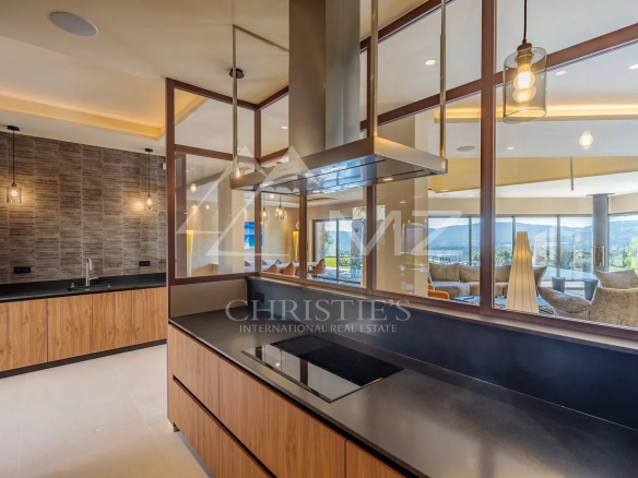 Intérieur d'une villa moderne avec cuisine ouverte et vue sur un séjour spacieux à Ramatuelle.