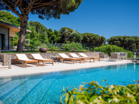 Vue de la piscine et des transats dans une propriété de luxe à Ramatuelle.