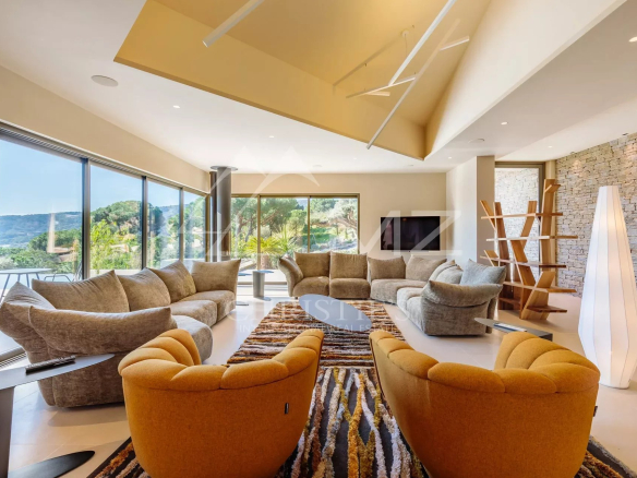 Intérieur d'une villa moderne avec un grand salon lumineux et des canapés confortables à Ramatuelle.