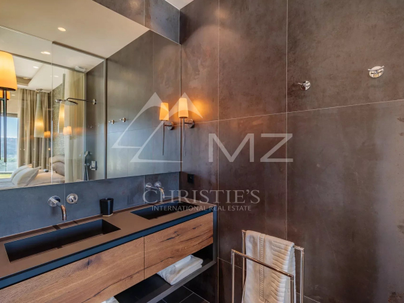Salle de bain moderne avec lavabo en bois et miroir, éclairage élégant.