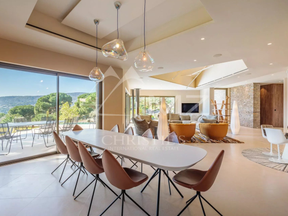 Intérieur d'une villa moderne avec salle à manger et vue sur la nature à Ramatuelle.