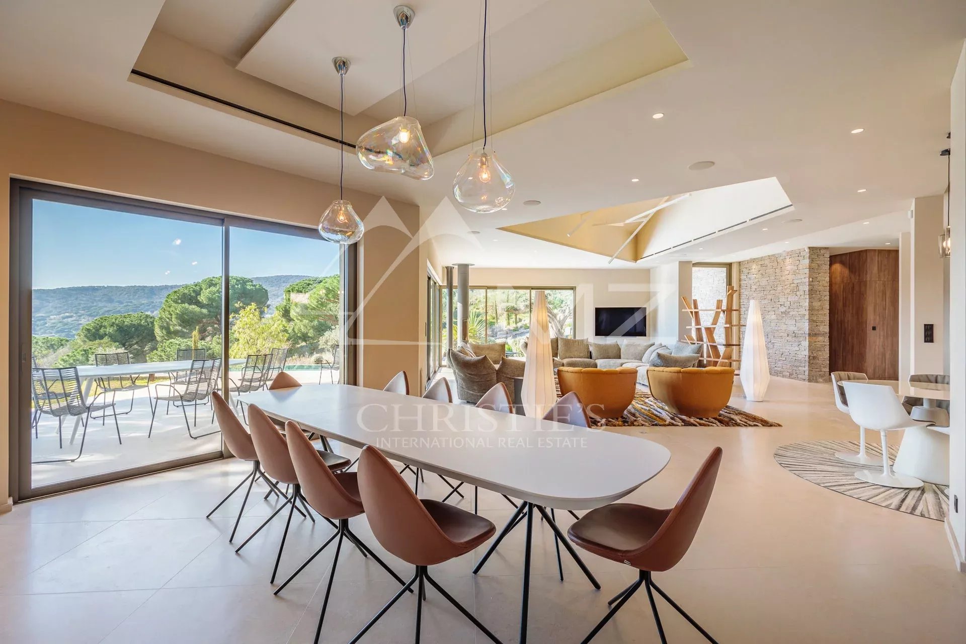 Intérieur d’une villa à Ramatuelle Intérieur d'une villa moderne avec salle à manger et vue sur la nature à Ramatuelle.
