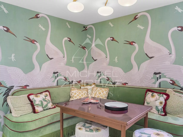Salon d'un duplex à Saint-Tropez avec décoration murale de grues et mobilier élégant.