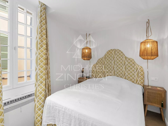 Chambre d'un duplex rénové à Saint-Tropez avec décoration élégante et luminaires en osier.