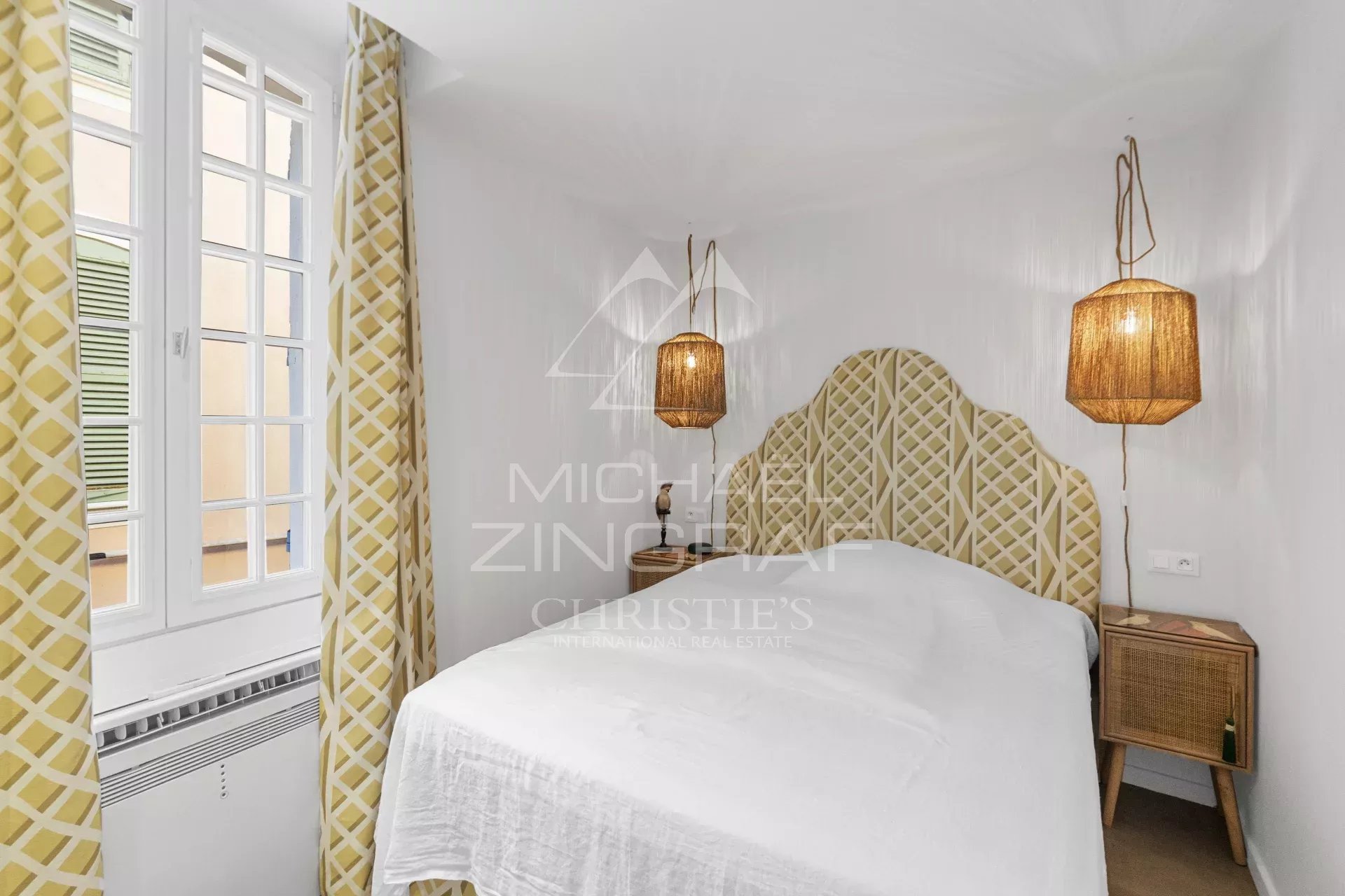 Chambre d’un duplex à Saint-Tropez Chambre d'un duplex rénové à Saint-Tropez avec décoration élégante et luminaires en osier.
