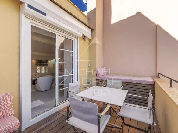 Terrasse d'un duplex à Saint-Tropez avec mobilier extérieur et vue sur le ciel.