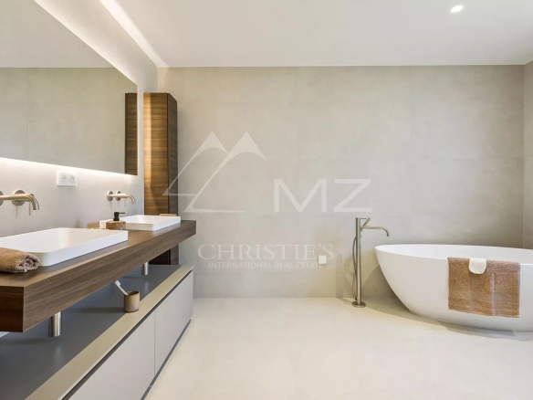 Salle de bain moderne avec baignoire et double vasque dans une villa contemporaine.