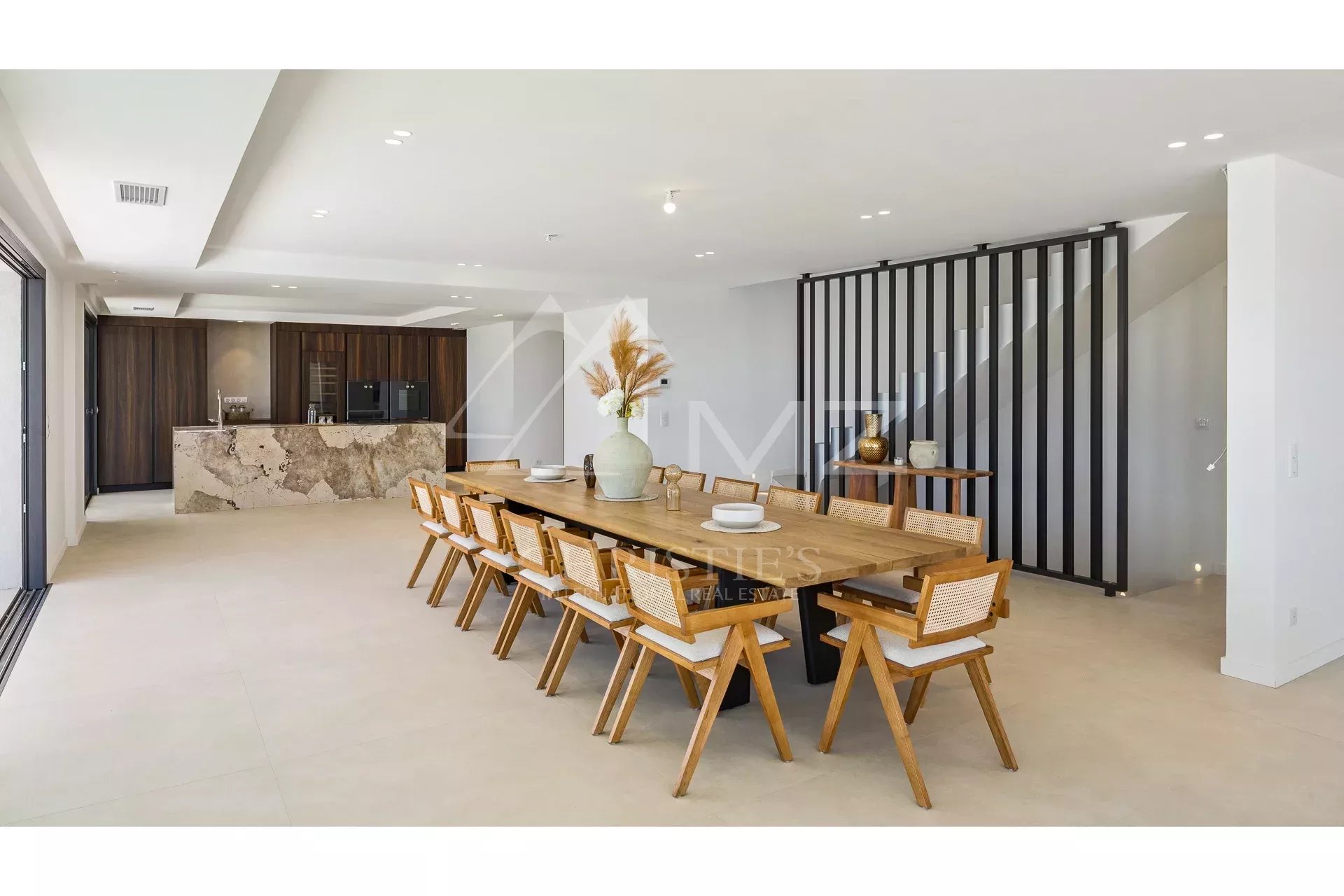 Intérieur d’une villa contemporaine Intérieur d'une villa contemporaine avec une grande table à manger en bois et un coin cuisine.