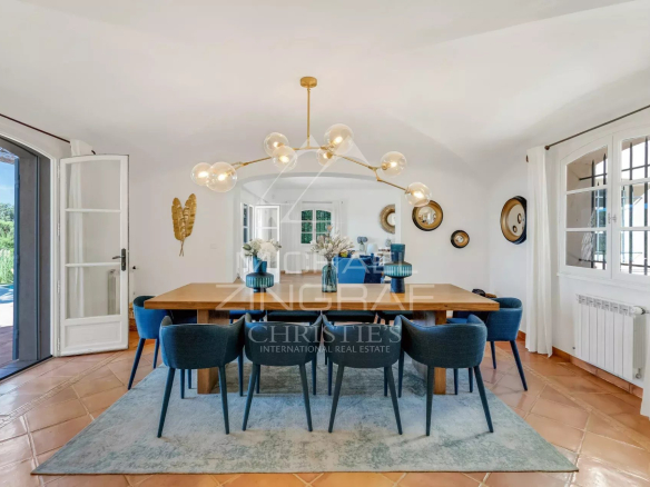 Dining room of a neo-Provençal villa with a large table and modern chairs.