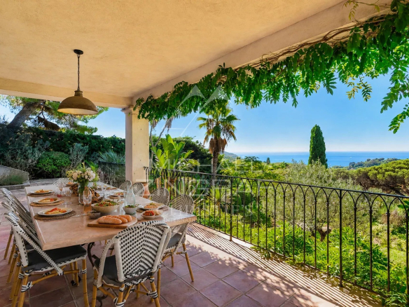 Terrace with set table offering a view of the sea and surrounding vegetation in La Croix-Valmer.