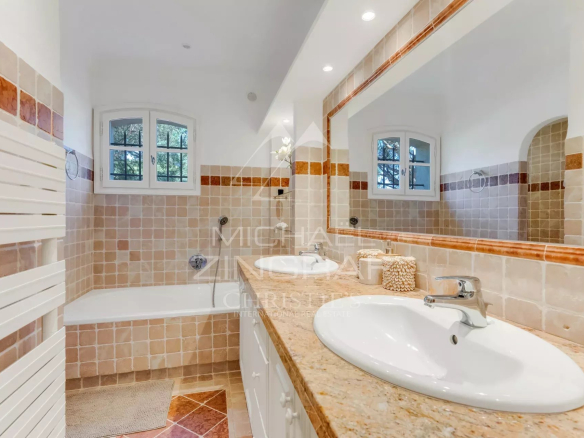 Spacious bathroom with bathtub and double sink in a neo-Provençal villa.