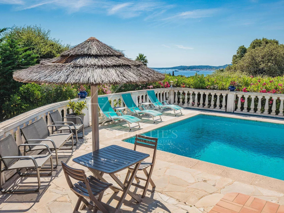 Vue de la piscine et du jardin d'une villa provençale à Grimaud, avec vue sur la mer et le village de Saint-Tropez.