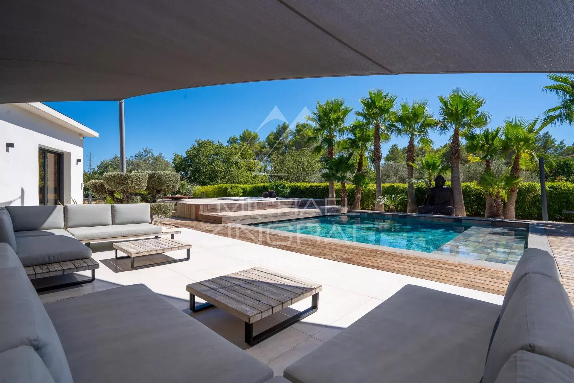 Vue d'une villa contemporaine avec piscine entourée de palmiers à Draguignan.