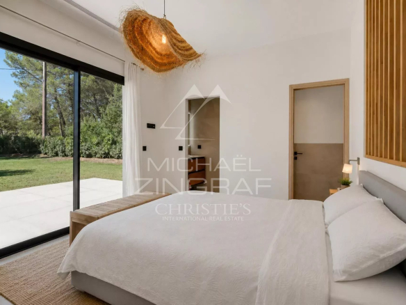 Chambre moderne avec lit double et accès à un jardin verdoyant à Draguignan.