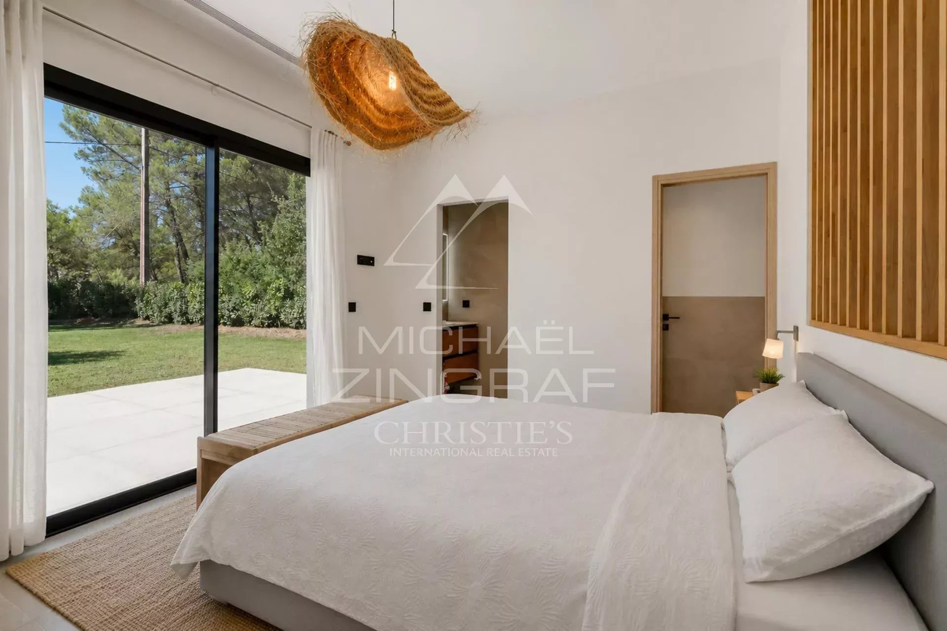 Chambre moderne avec lit double et accès à un jardin verdoyant à Draguignan.