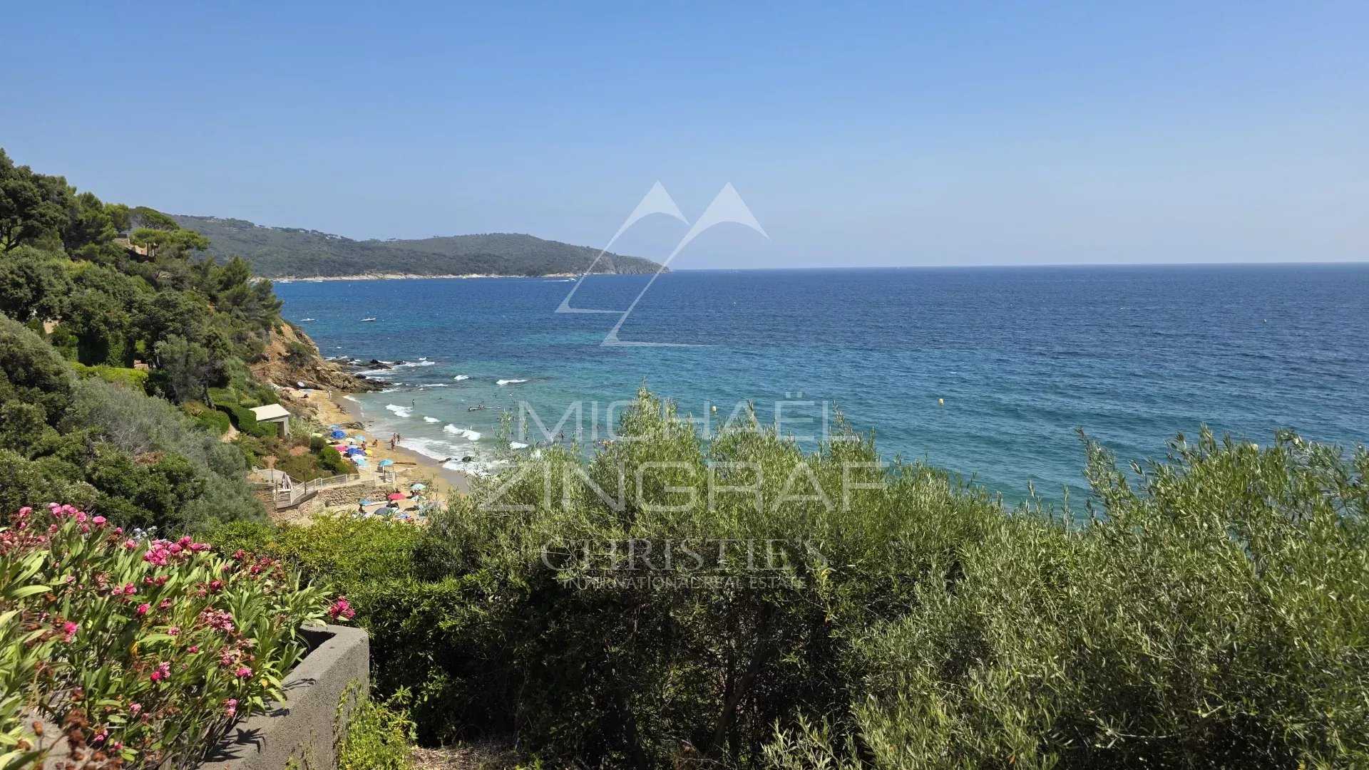 Vue sur la mer depuis une villa à La Croix-Valmer, avec des plages et des collines en arrière-plan.