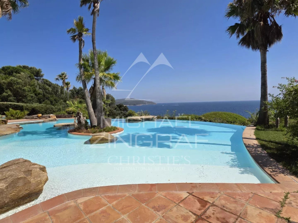 Vue de la piscine et du jardin d'une villa pieds dans l'eau à La Croix-Valmer, près de Saint-Tropez.