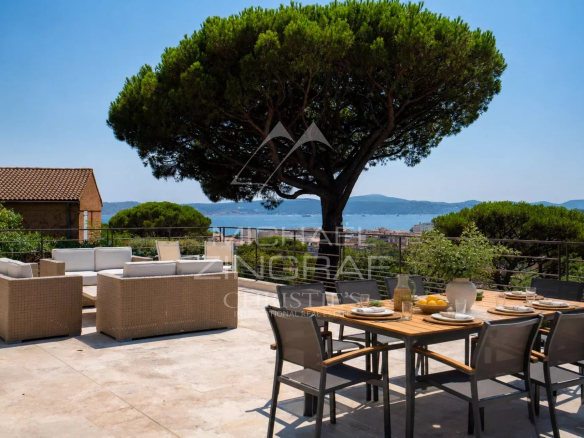 Terrace of a villa in Sainte-Maxime with garden furniture and sea view.