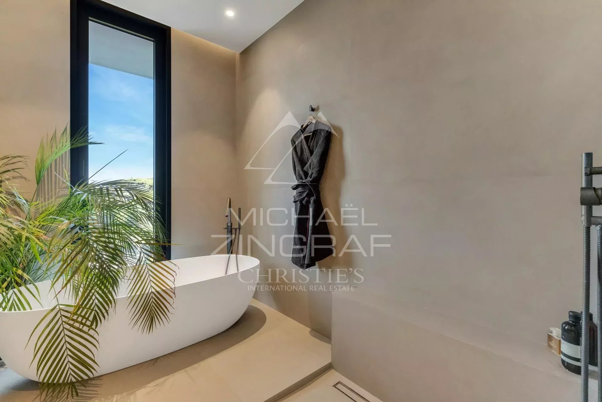 Contemporary bathroom Modern bathroom with freestanding bathtub and view of the outside, decorated with plants.