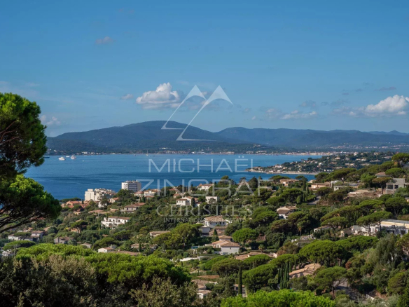 Panoramic view of the Gulf of Saint-Tropez from Sainte-Maxime, with hills and houses.