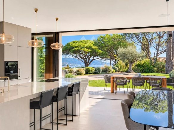 Interior of a contemporary villa with modern kitchen and views of the garden and the Gulf of Saint-Tropez.