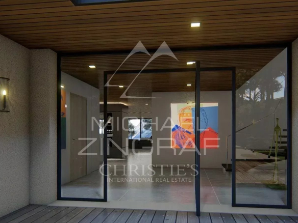 Entrée moderne d'une propriété au Lavandou avec des portes vitrées et un intérieur lumineux.