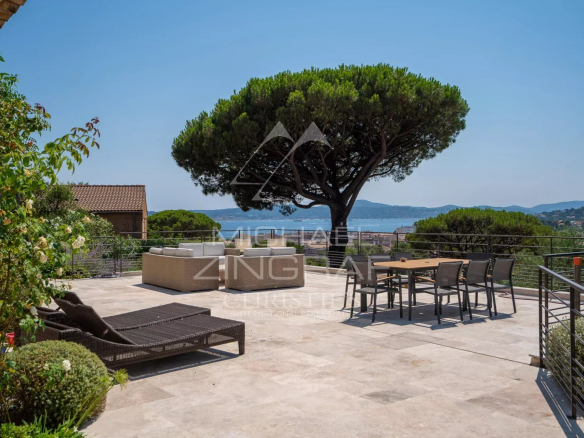 Terrace of a villa in Sainte-Maxime with a view of the sea and a large pine tree.