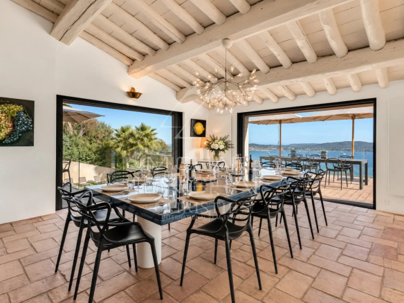 Modern dining room with views of the Gulf of Saint-Tropez, large windows and elegant decor.